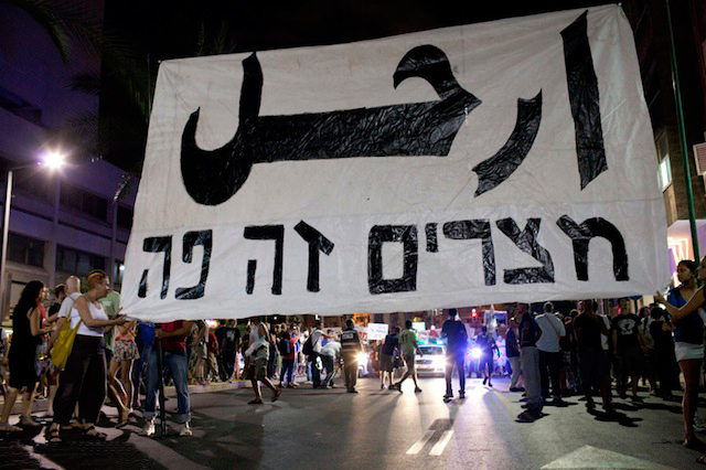 Protesters hold a banner says 'Go! (in Arabic), Egypt Is Here!,' Tel Aviv, August 6, 2011.