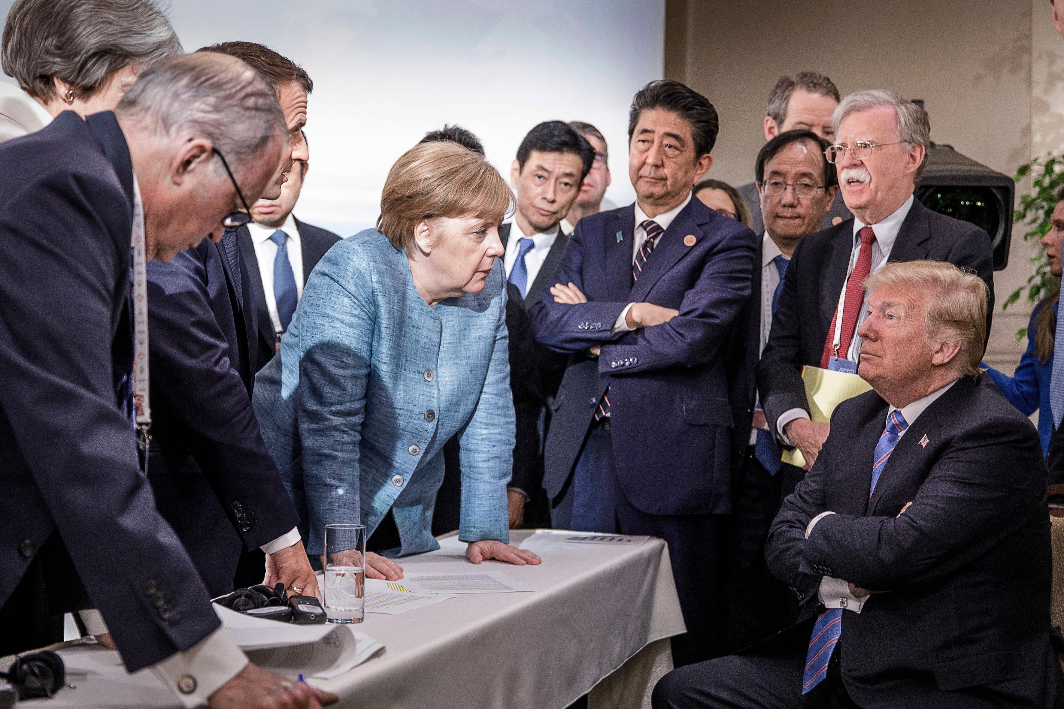 G7 leaders surround U.S. President Donald Trump, who is sitting down and watching, and his national security adviser John Bolton, the 44th G7 summit, La Malbaie, Quebec, Canada, June 9, 2018.